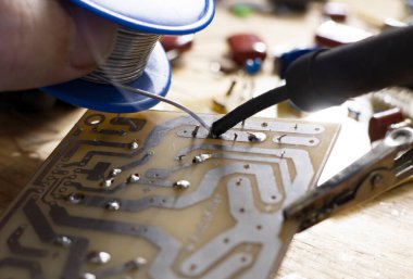 Elektronik parçalı elektronik devre kartının lehimlenmesi. Mühendisler devre kartını tamir ediyor.