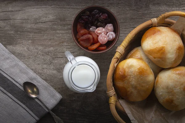 木製のテーブルの上にホットクロスパンはミルクとドライフルーツ クリームのジャグを添えています トップビュー コピースペース イースターベーキング — ストック写真