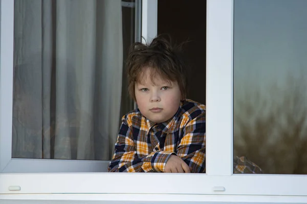 Мальчик Смотрит Окно Пандемической Изоляции Ребенок Сидит Подоконнике Время Короновируса — стоковое фото