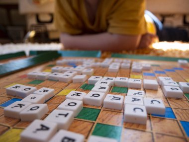 Belgorod, Rusya - 13, 2020: Çocuklar yerde Rusça Scrabble oynuyor. Masa oyunu çipleri bulmacada gizlidir. Eğitim, eğlence konsepti Okula geri dönüş