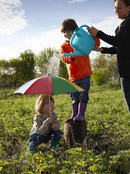 雨の屋外で2人の男の子の遊び 幸せな兄弟ゲーム — ストック写真