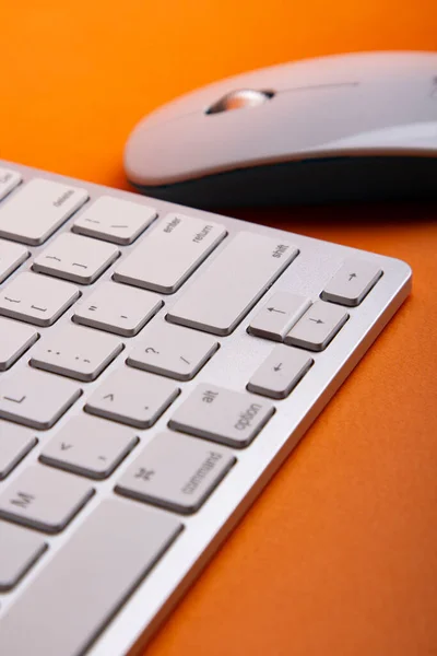 オレンジのテーブルの上の白いキーボードとマウス — ストック写真