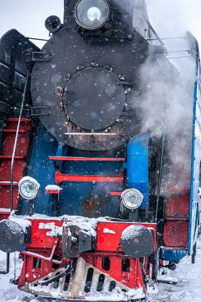 New Year\'s steam engine in the winter. Close-up of an old snow-c