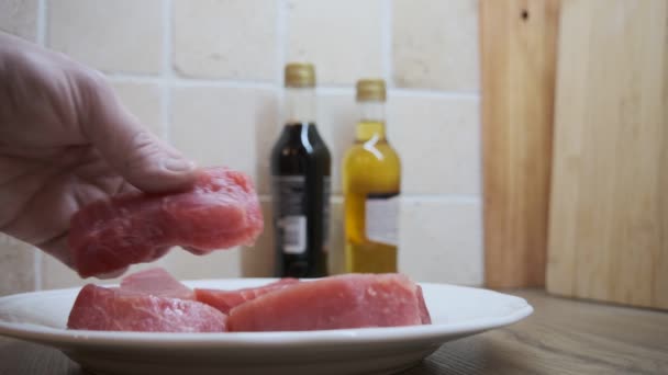 多汁的金枪鱼蒸煮好了 躺在厨房工作台上的白盘上 雄性手翻动一块金枪鱼 — 图库视频影像
