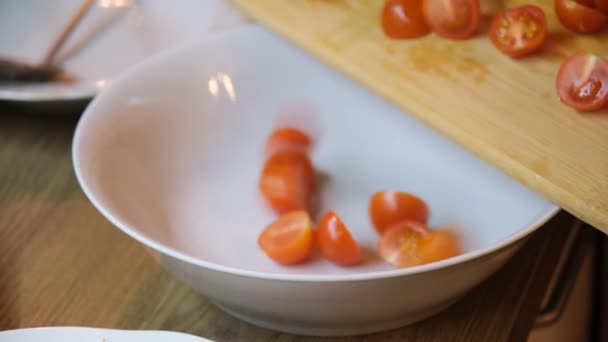 Het Meisje Giet Gehakte Kerstomaten Een Witte Slakom Een Salade — Stockvideo