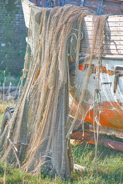 Un viejo bote de pesca pelado se encuentra en la orilla. Una red de pesca h — Foto de Stock