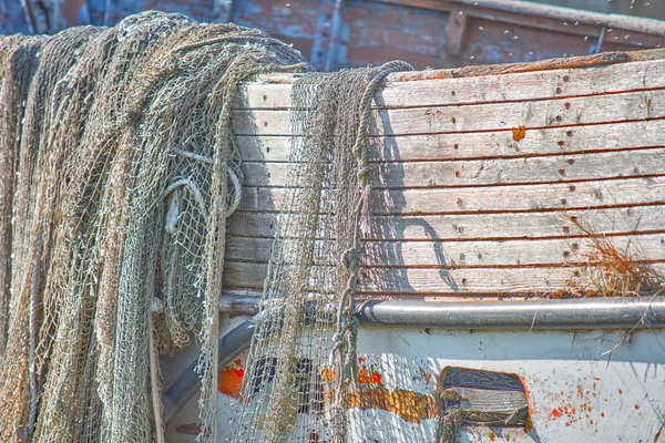 Un viejo bote de pesca pelado se encuentra en la orilla. Una red de pesca h — Foto de Stock