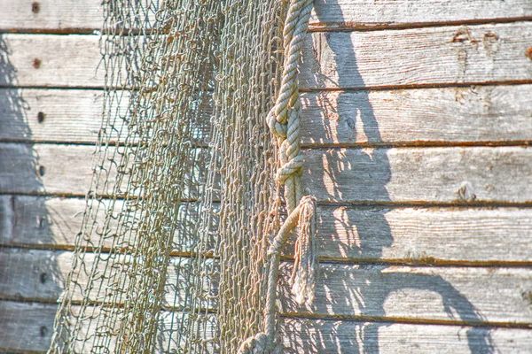 Kıyıda eski bir balıkçı teknesi duruyor. Bir balık ağı. — Stok fotoğraf