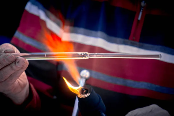 Närbild av händerna på en glasblåsare som arbetar på ett glasföremål — Stockfoto