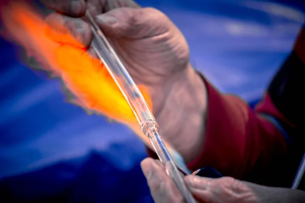 Primer plano de las manos de un soplador de vidrio que trabaja en un objeto de vidrio — Foto de Stock
