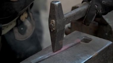 Demirci demir ocağında çalışıyor. Sıcak metal, kıvılcımlar ve kömürler. Bir ateş yanıyor, metal boşluklar eriyor..