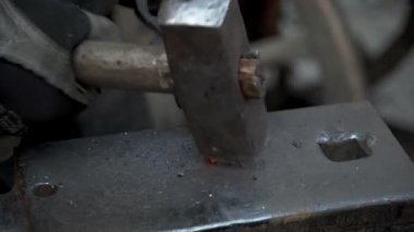 Demirci demir ocağında çalışıyor. Sıcak metal, kıvılcımlar ve kömürler. Bir ateş yanıyor, metal boşluklar eriyor..