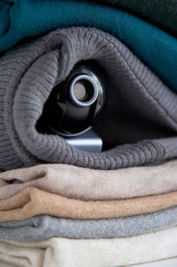 Webcam, evin gizli kameraları için giysi yığınının içine gizlenmiş. Gözetleme ve güvenlik sistemleri. Akıllı Ev. Casusluk. İzlemek için gizli kamera