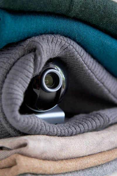 Webcam hidden in a stack of clothes for covert surveillance of the house. Surveillance and security systems. Smart House. Espionage. Hidden camera for watching