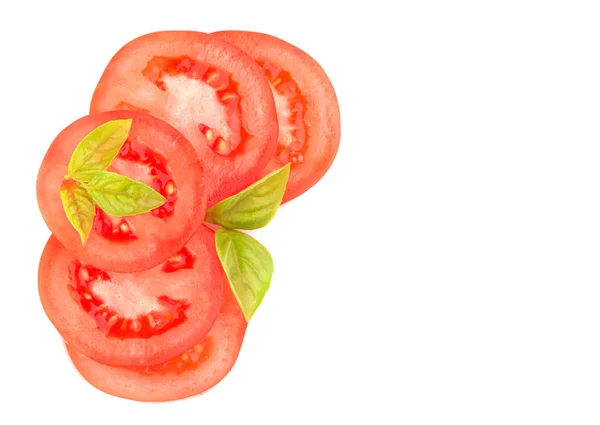 Rodajas de tomate con hojas de albahaca, en esquina con espacio para copiar, sobre fondo blanco —  Fotos de Stock