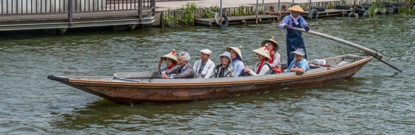Местные жители и туристы катаются на деревянной лодке на ежегодном фестивале цветов Iris Suigo Itako — стоковое фото