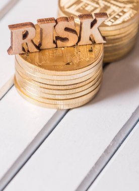 Altın sikke üzerinde ahşap masa üstü metinle riske