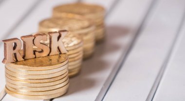 Altın sikke üzerinde ahşap masa üstü metinle riske