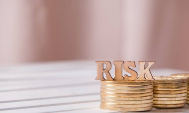 Altın sikke üzerinde ahşap masa üstü metinle riske