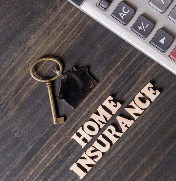 家庭保险与房子钥匙和计算器在木桌顶部 — 图库照片