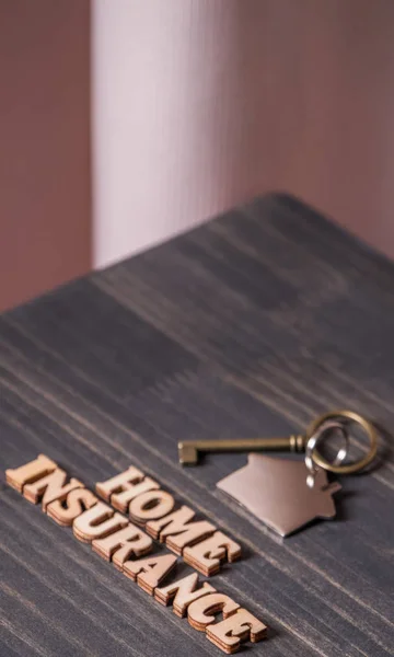 家庭保险文本与房子钥匙在木桌顶部 — 图库照片