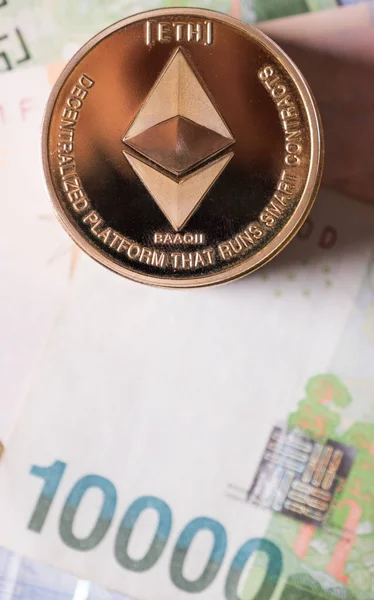 Ethereum coin on South Korean won bank notes