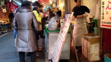 Gıda ahır sahibi müşterilerini Tsukiji Market, Tokyo, Japam, eğlenceli