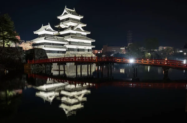 木红色桥梁和松本城堡在晚上 — 图库照片