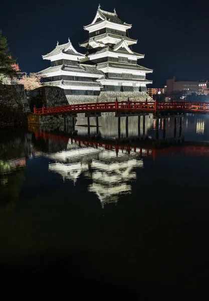 木红色桥梁和松本城堡在晚上 — 图库照片