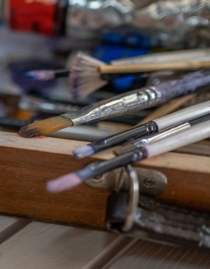 Tahtadaki eski fırçalar ve yağlı boya tüpleri.