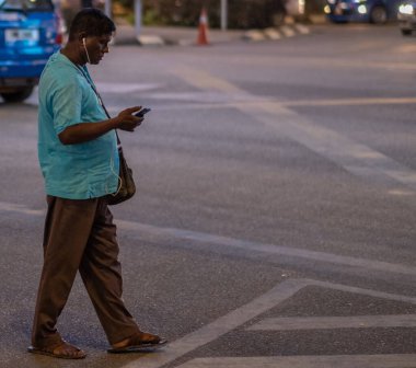 Genç adam sokakta yürüyor.
