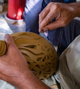 Bir çömlekçinin eliyle bir adamın ellerini kapat.