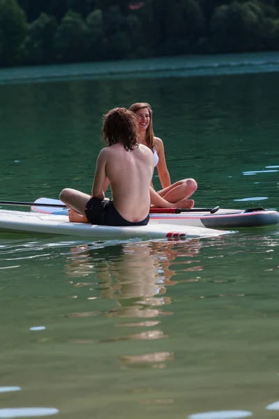 Para Zakochanych Odzyskuje Wodzie Siedząc Deskę Surfingową — Zdjęcie stockowe