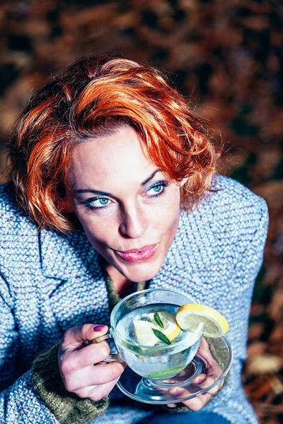 Red Haired Woman Kneels Leaves Glass Tea Her Hand — ストック写真