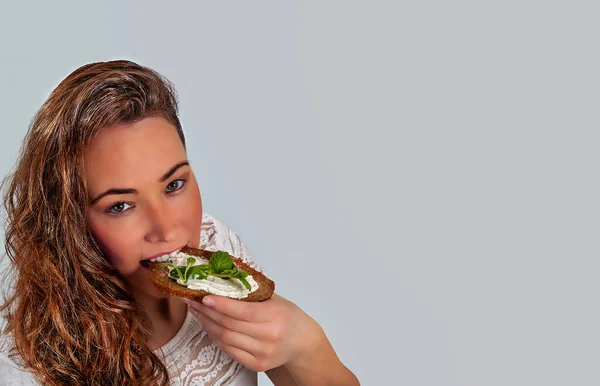 Giovane Donna Che Mangia Una Fetta Pane Con Crema Formaggio — Foto Stock