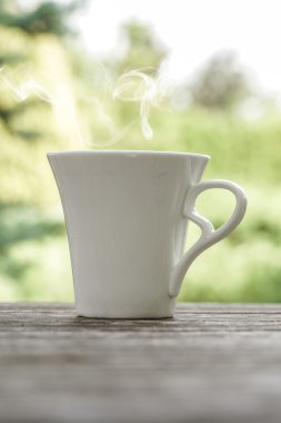 ahşap bir masa üzerinde beyaz kahve fincanı