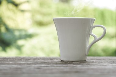 ahşap bir masa üzerinde beyaz kahve fincanı