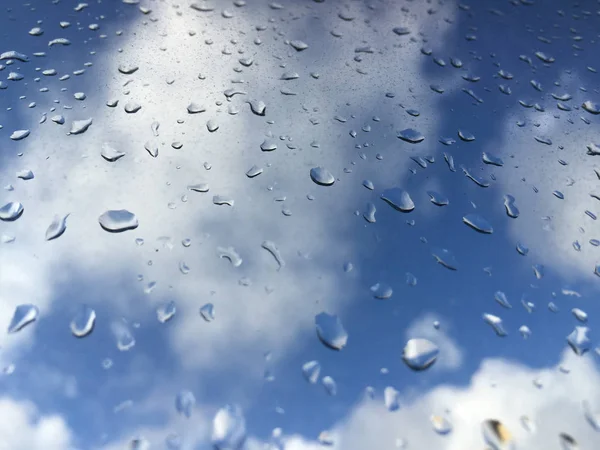 Regentropfen auf Fensterscheibe gegen Wolken — Stockfoto