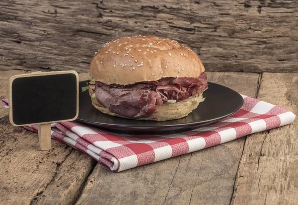 Pečené hovězí burger a tabuli na dřevěný stůl — Stock fotografie