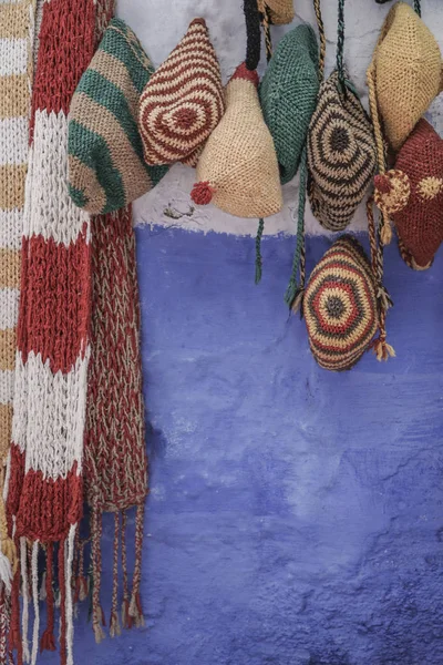 Chapéus coloridos de malha e cachecóis pendurados na parede — Fotografia de Stock