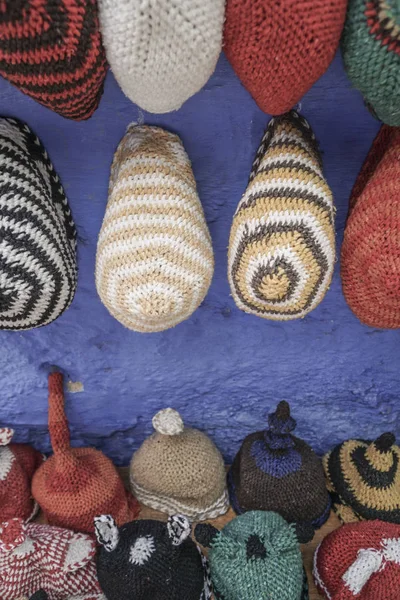 Chapéus coloridos de malha pendurados na parede — Fotografia de Stock
