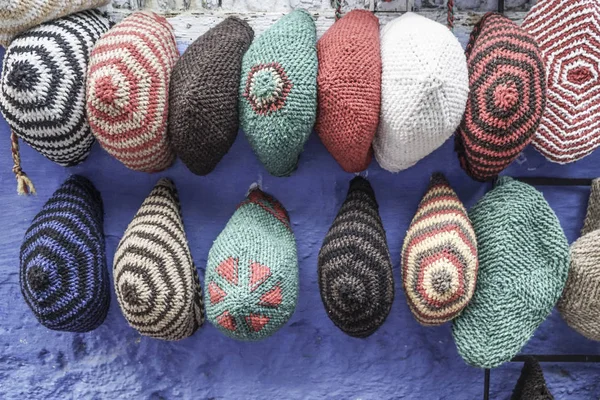 Chapéus coloridos de malha pendurados na parede — Fotografia de Stock