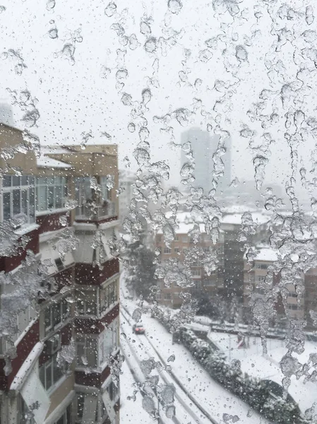 Hielo en la ventana contra la calle bajo nieve — Foto de Stock