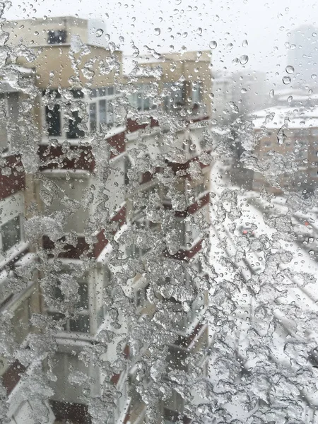 Hielo en la ventana contra la calle bajo nieve — Foto de Stock