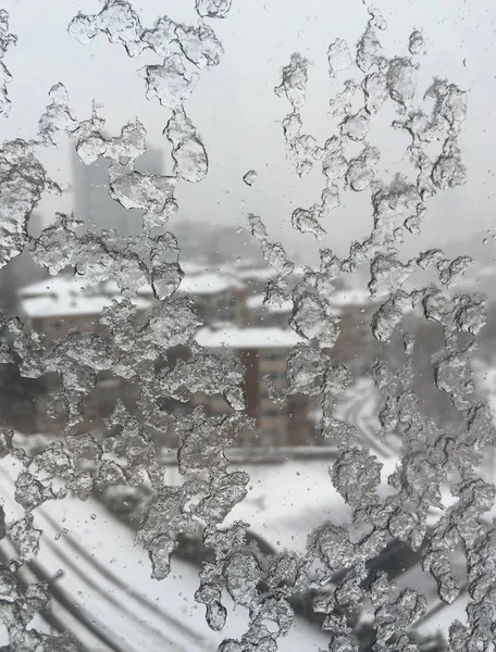 Hielo en la ventana contra la calle bajo nieve — Foto de Stock