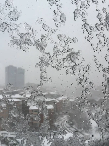 Hielo en la ventana contra la calle bajo nieve —  Fotos de Stock