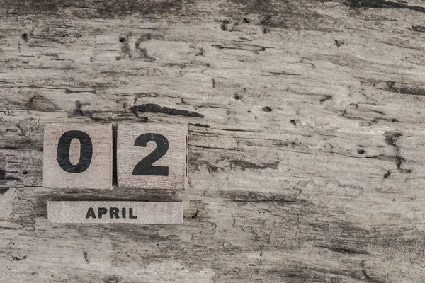 Календарь куба для апреля на деревянном фоне — стоковое фото