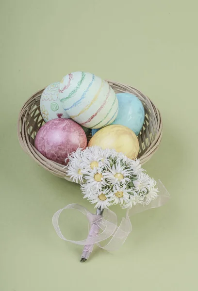 Colorful easter eggs in a basket on green — Stock Photo, Image