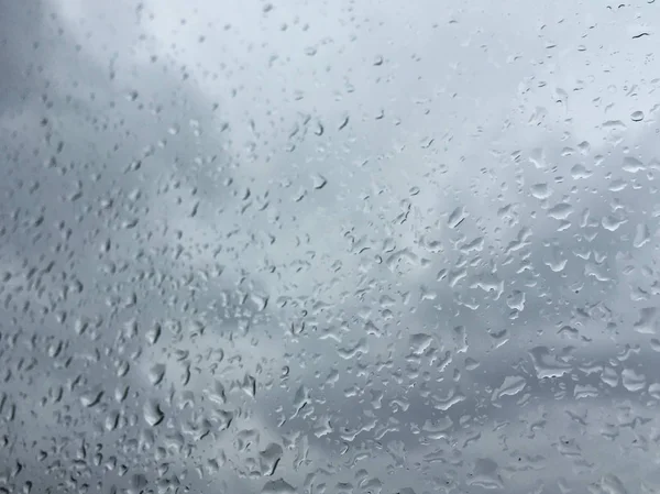 Regen druppels op venster tegen humeurig hemel — Stockfoto
