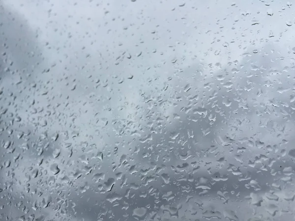 Regen druppels op venster tegen humeurig hemel — Stockfoto